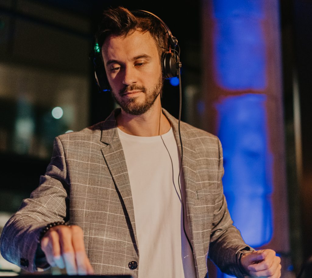 DJ Bury with headphones mixing house at an evening corporate gala