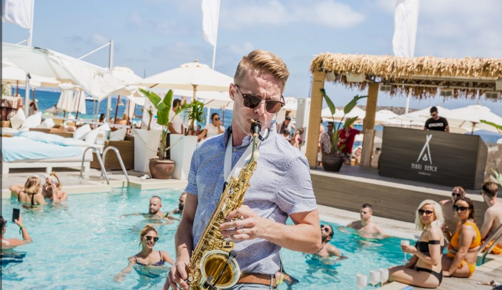 Saxofonista DeeSaxx hraje u bazénu na pool party eventu v Nikki Beach Mallorca