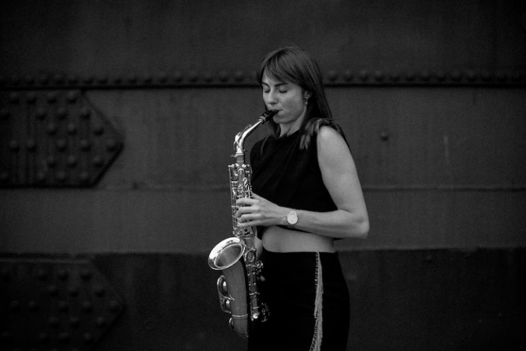 Black-and-white photo of saxophonist Nikisaxi with her saxophone – saxophonist for events in Brno
