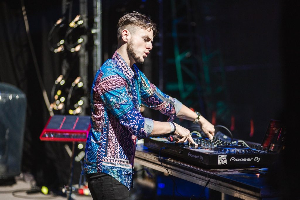 DJ Václav Brom in a patterned shirt behind the decks on stage – DJ for corporate events in Brno