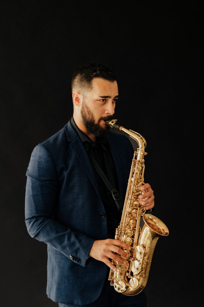 Saxophonist Johny Sax in a jacket playing saxophone – saxophonist for corporate parties in Brno