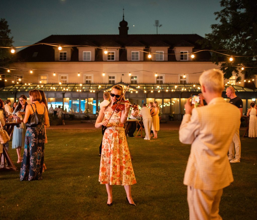 Violinist Alžběta Králová playing among guests at the AHK Sommerfest 2026 garden party in Bratislava
