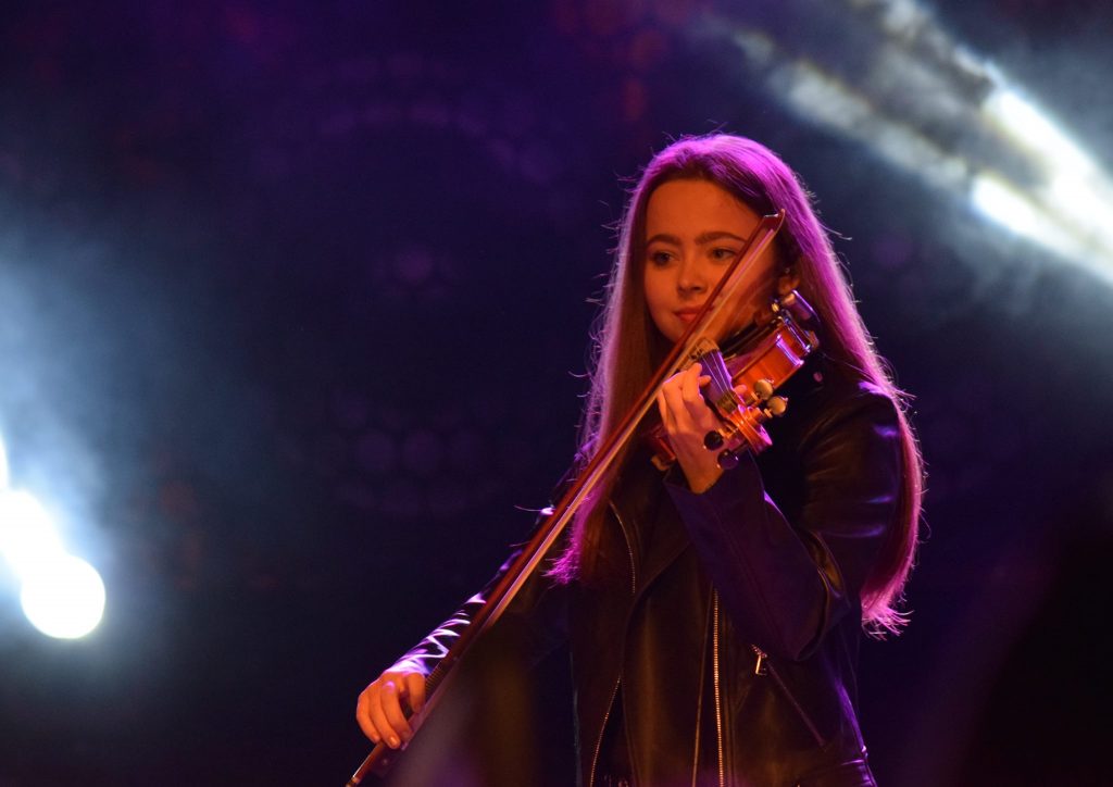 Violinist Alžběta Králová playing on stage in the spotlight at a corporate gala