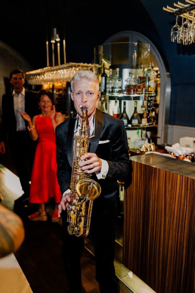 Saxofonista DeeSaxx hraje v obleku na večerní akci