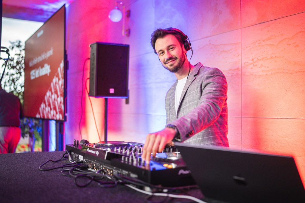 DJ Bury playing at the decks under colourful lights at Miele’s 125th anniversary at Villa Stiassni in Brno