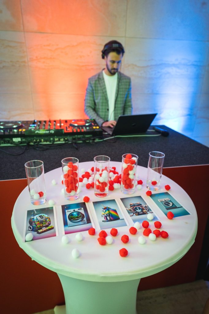 DJ Bury at the decks at the Miele garden party, with a table of drinks in the foreground