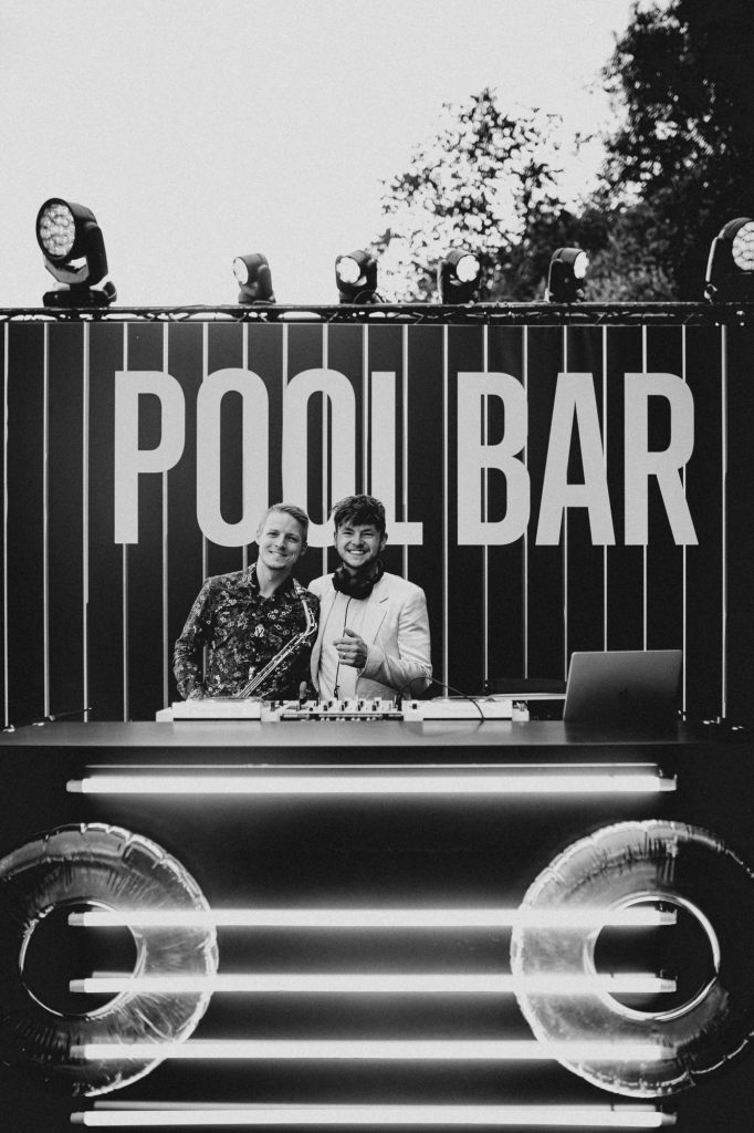 DJ Václav Brom a saxofonista DeeSaxx u DJ pultu Pool Baru na party Accolade, KVIFF 2022, hotel Thermal