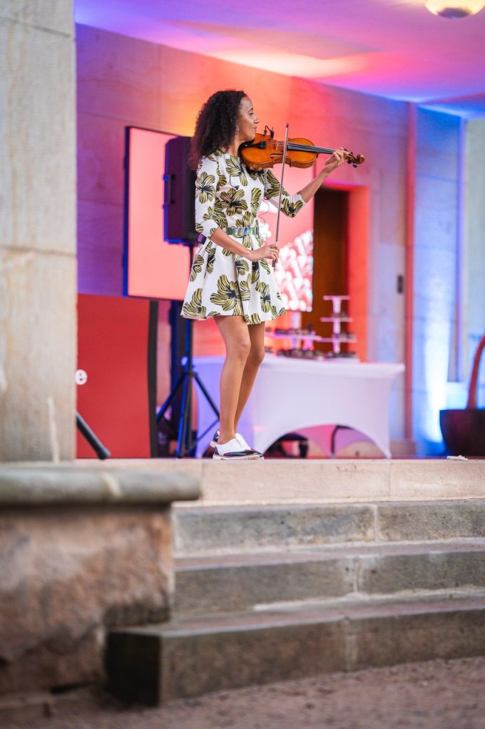Violinist Iska.muse playing on the stone steps of Villa Stiassni in Brno