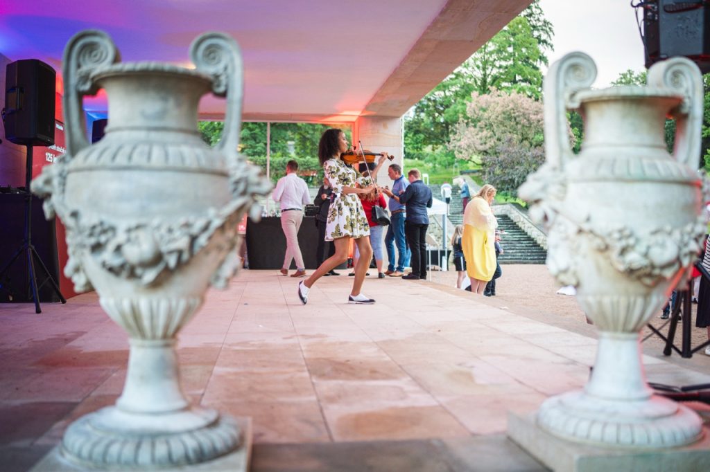 The gardens of Villa Stiassni in Brno with stone urns and guests at the Miele garden party